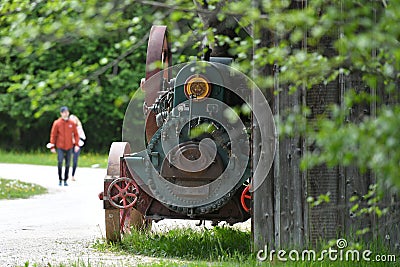 Old steam engine in the open-air museum with old farmhouses and buildings in GroÃŸgmain in Salzburg Editorial Stock Photo